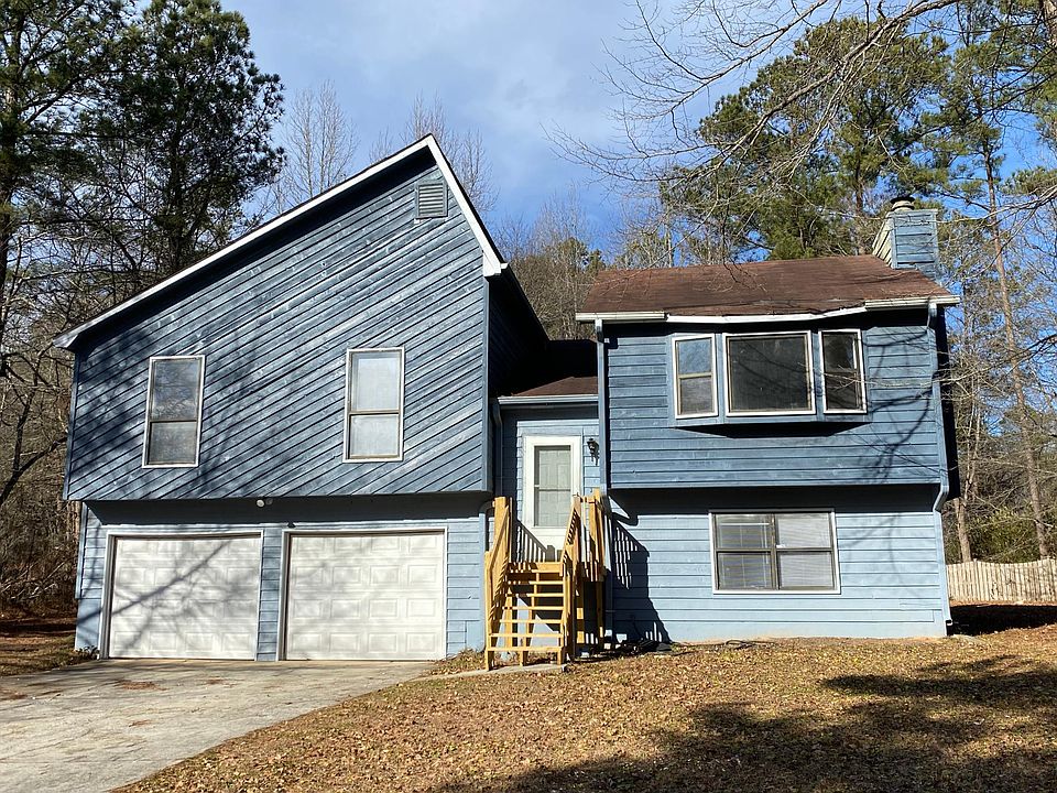 A home with a spacious back deck and newly installed steps leading up to the house.
