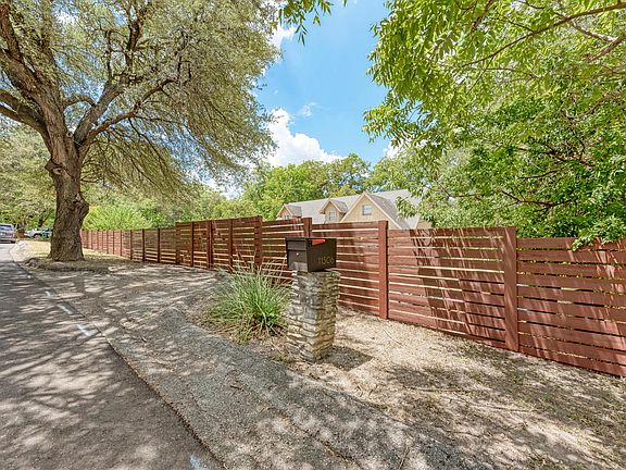 Cedar privacy fence spans the entire front face of the property.
