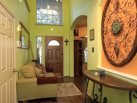 Open entryway leads to formal dining, garage access, and hall to stairs/living area.