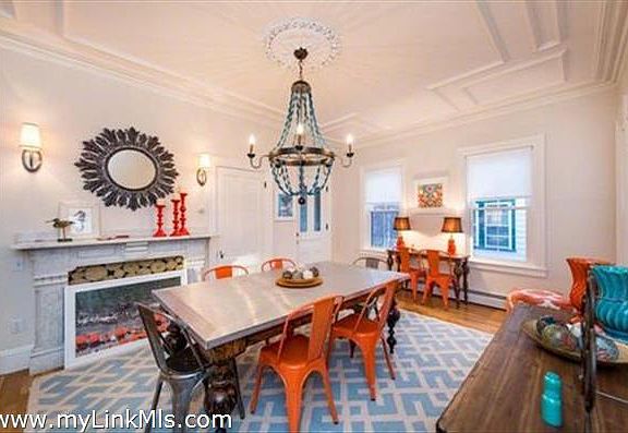 Delightful dining room with marble mantel, decorative molding s on high ceiling, wood floors and fabulous lighting.