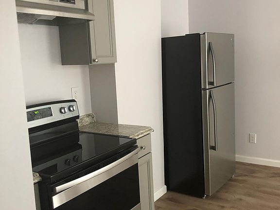 Stainless steel refrigerator, stove and range hood.