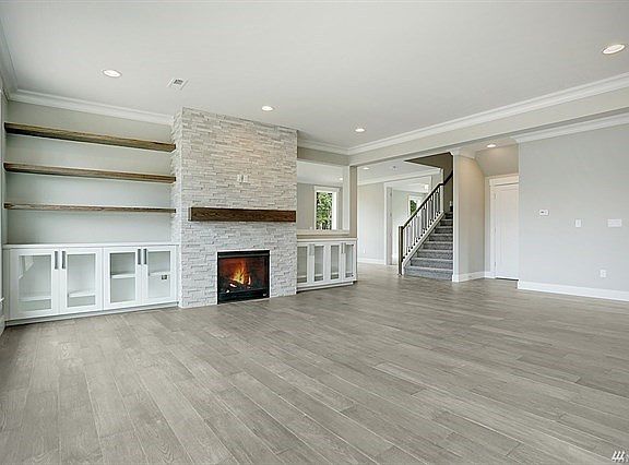 Living room with crown molding, customer cabinets, shelves and gas fireplace