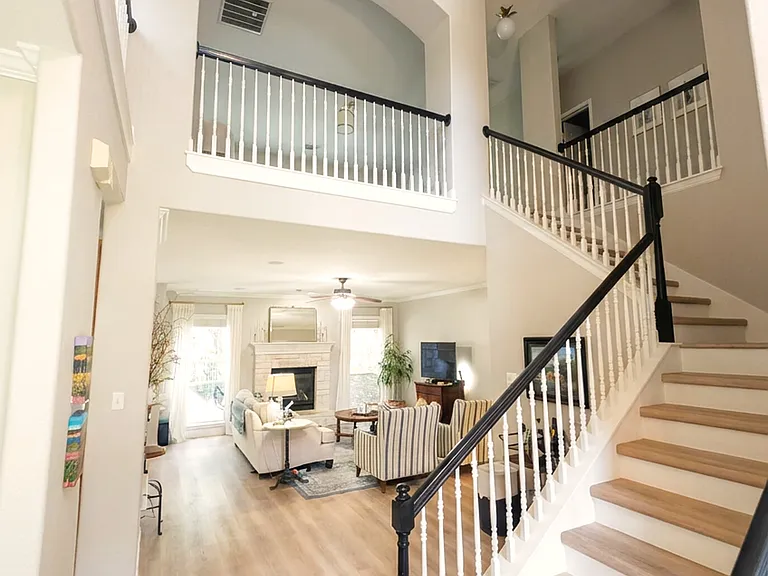 Dramatic two-story foyer with a curved staircase and abundant natural light