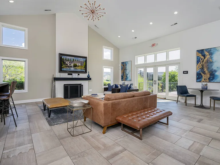 Gather and unwind in a warm, welcoming community space, centered around a cozy fireplace and comfortable seating.