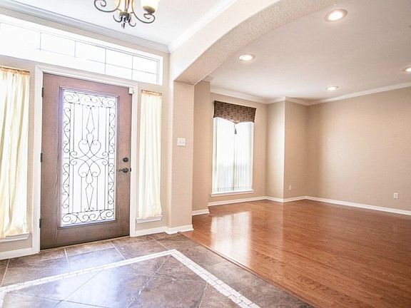Bright entry & formal living room with classic hard wood flooring
