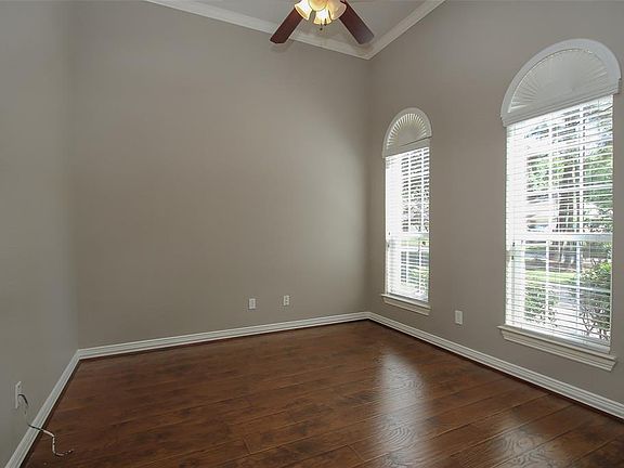 High ceilings, arched windows with custom shutters and crown molding adorns this study!