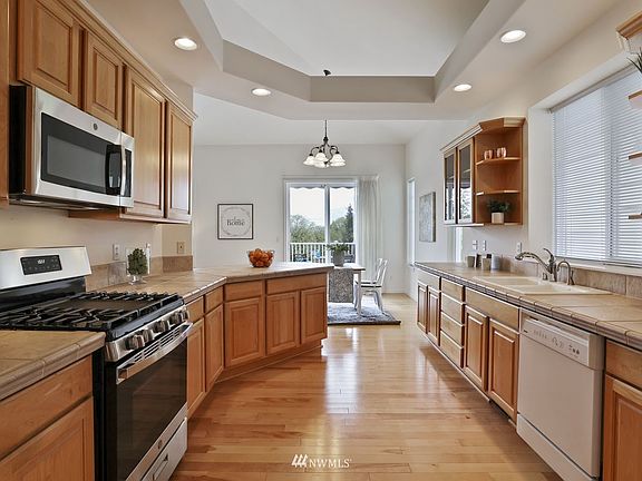 Kitchen with hardwood floors, new gas range and microwave.>