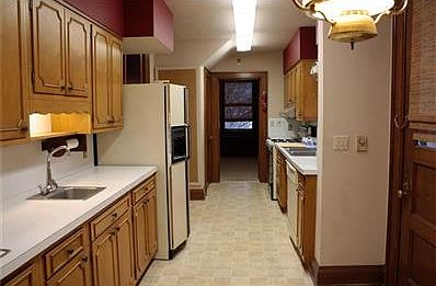 Efficient kitchen with custom wood cabinetry. Slide out shelves and pull-out mixer stand. Trash shoot under kitchen sink empties into basement where a trash can is placed.