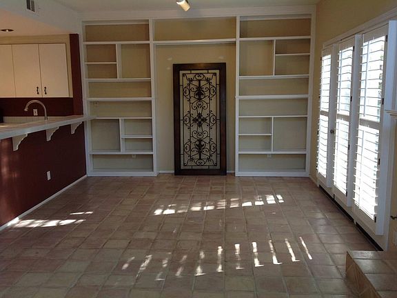 Dining area with built in bookcases. Iron work is optional. Floor now dark wood look porcelain tile. Wall below counter now neutral.