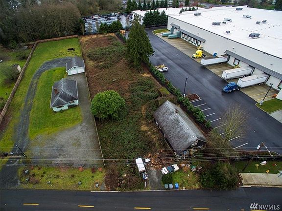 Shy 1 AC .98 zoned Puyallup RM-20-Multi-family residential/High density. Vacant lot in the middle of the picture, older home on lot. 