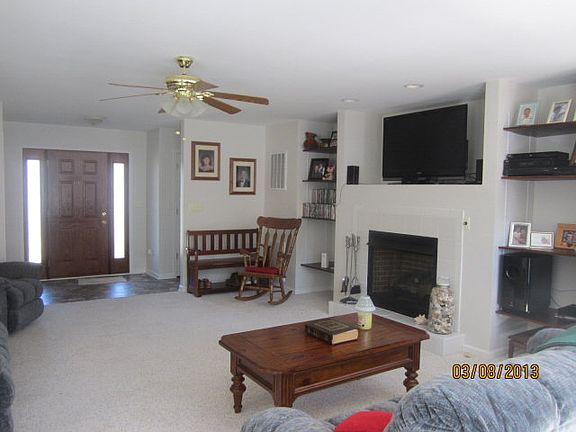 Living room has built in shelves that flank the fireplace.