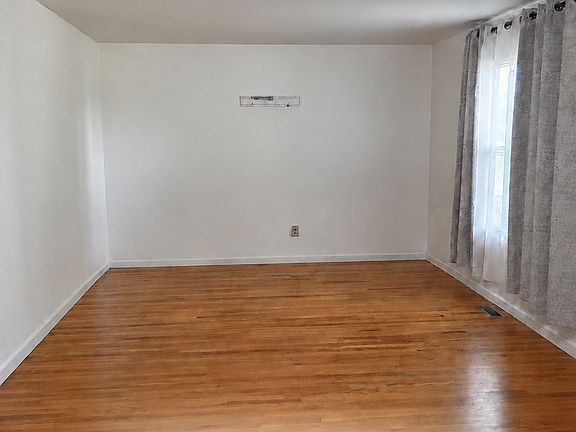 Spacious living room featuring beautiful hardwood floor and natural light.