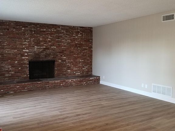 Living room with custom brick and wood burning fireplace.