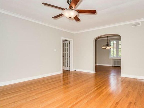 View from front door into living room and dining room and small hallway to bedrooms and bathroom. This photo was taken before the built-in shelling was constructed.
