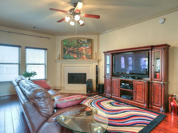 Welcoming family room in neutral colors with extensive crown molding and gas fireplace.