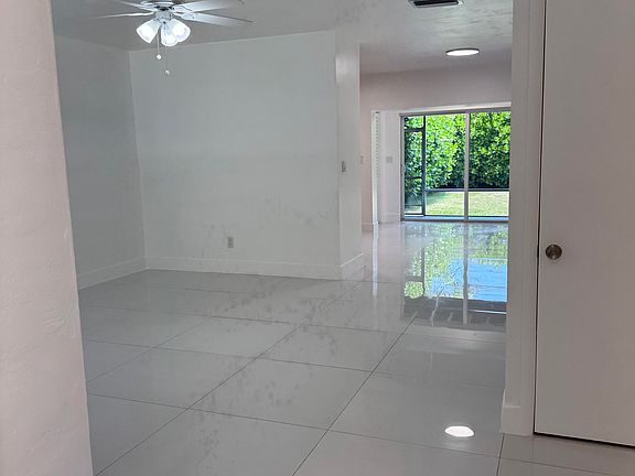 View from the entrance of the home, seeing the open floor plan and the double wide sliding glass door out to the screened-in back porch and private, landscaped backyard.