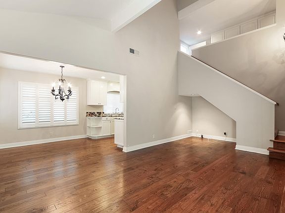 Living room to kitchen. Vaulted ceiling with chandelier and 
