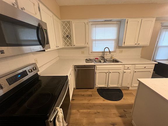 This shows the brand new custom built wine rack, the LVP flooring, granite countertops and stainless steel appliances new kitchen hardware, freshly painted