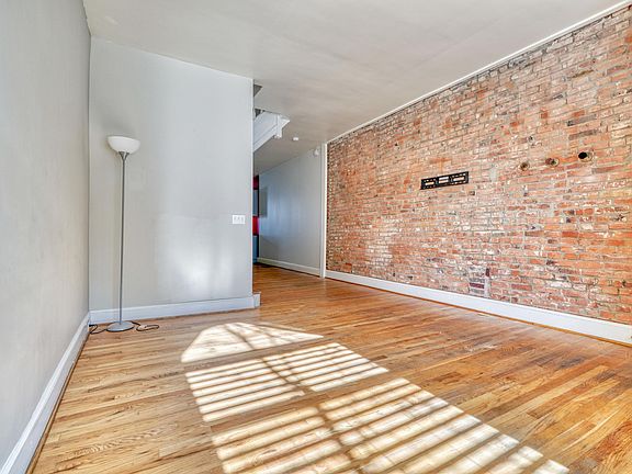SPACIOUS LIVING RM w/WOOD FLRS & BRICK ACCENT WALL