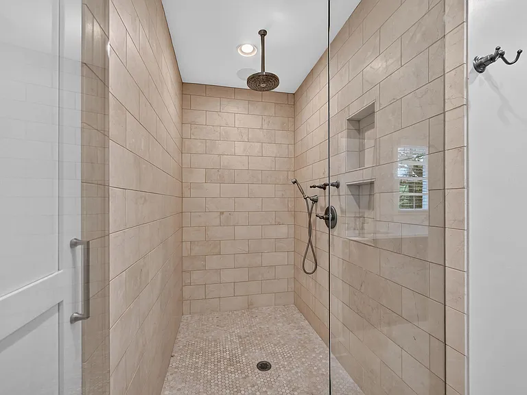 Large walk-in shower with rainhead and hand-held fixtures.