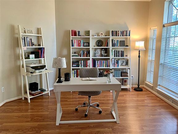 STUDY WITH DOUBLE CROWN MOLDING, NEUTRAL PAINT, AND LAMINATE FLOORING