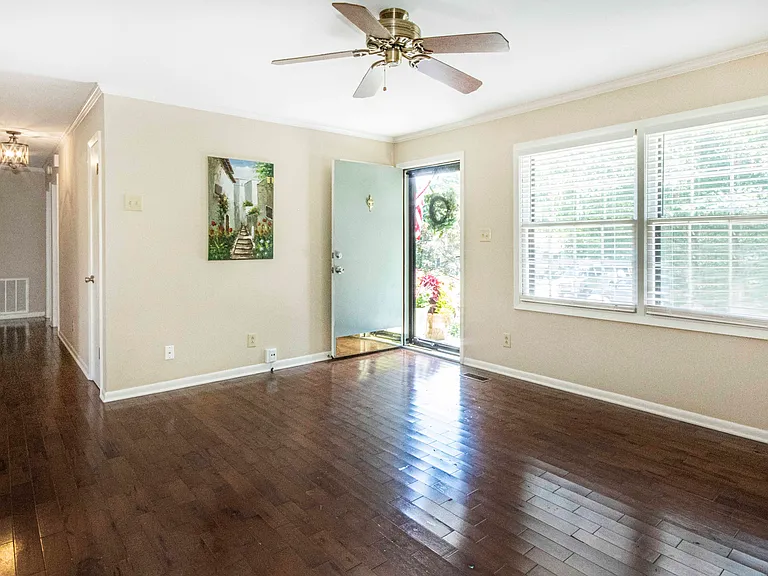 Gleaming hardwoods and fresh coat of paint plus large picture window makes this living room inviting.