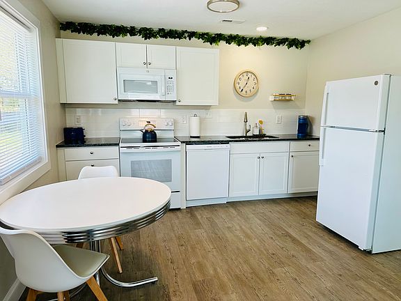 Open concept kitchen with full sized refrigerator, dishwasher, stove/oven, and microwave.