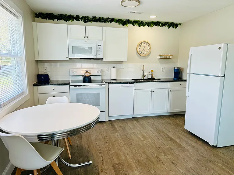 Open concept kitchen with full sized refrigerator, dishwasher, stove/oven, and microwave.