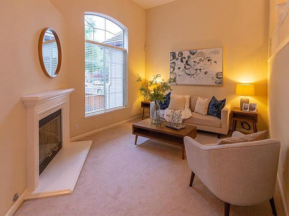 Living Room w/lots of natrual light, Cozy Fireplace & Vaulted Ceilings