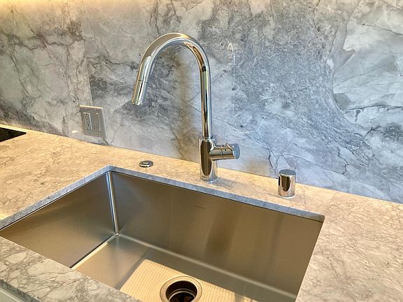Deep stainless steel sink with garbage disposal.