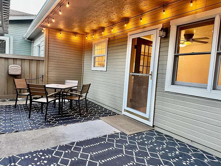 Private fenced front California lifestyle courtyard opens to kitchen & living room. Table & chairs, string lighting, & floor mats are included.