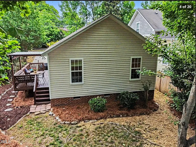 Fenced back yard with deck and driveway access.