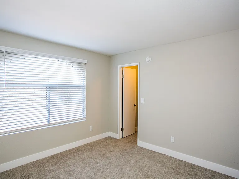 Bedroom with large baseboards, two-tone paint, tons of natural light, and door to closet.