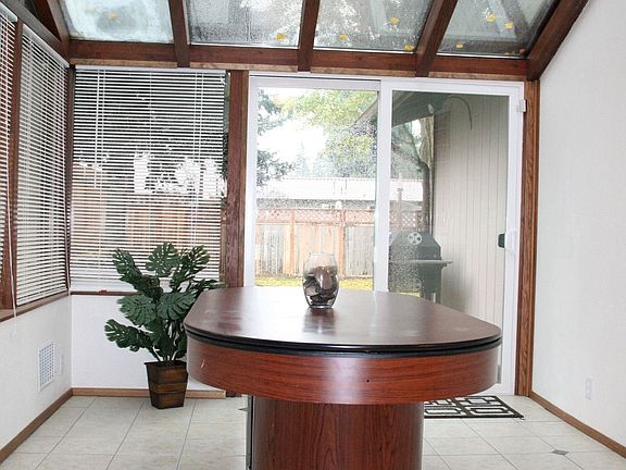 Sunroom with deck access and ceiling fan.