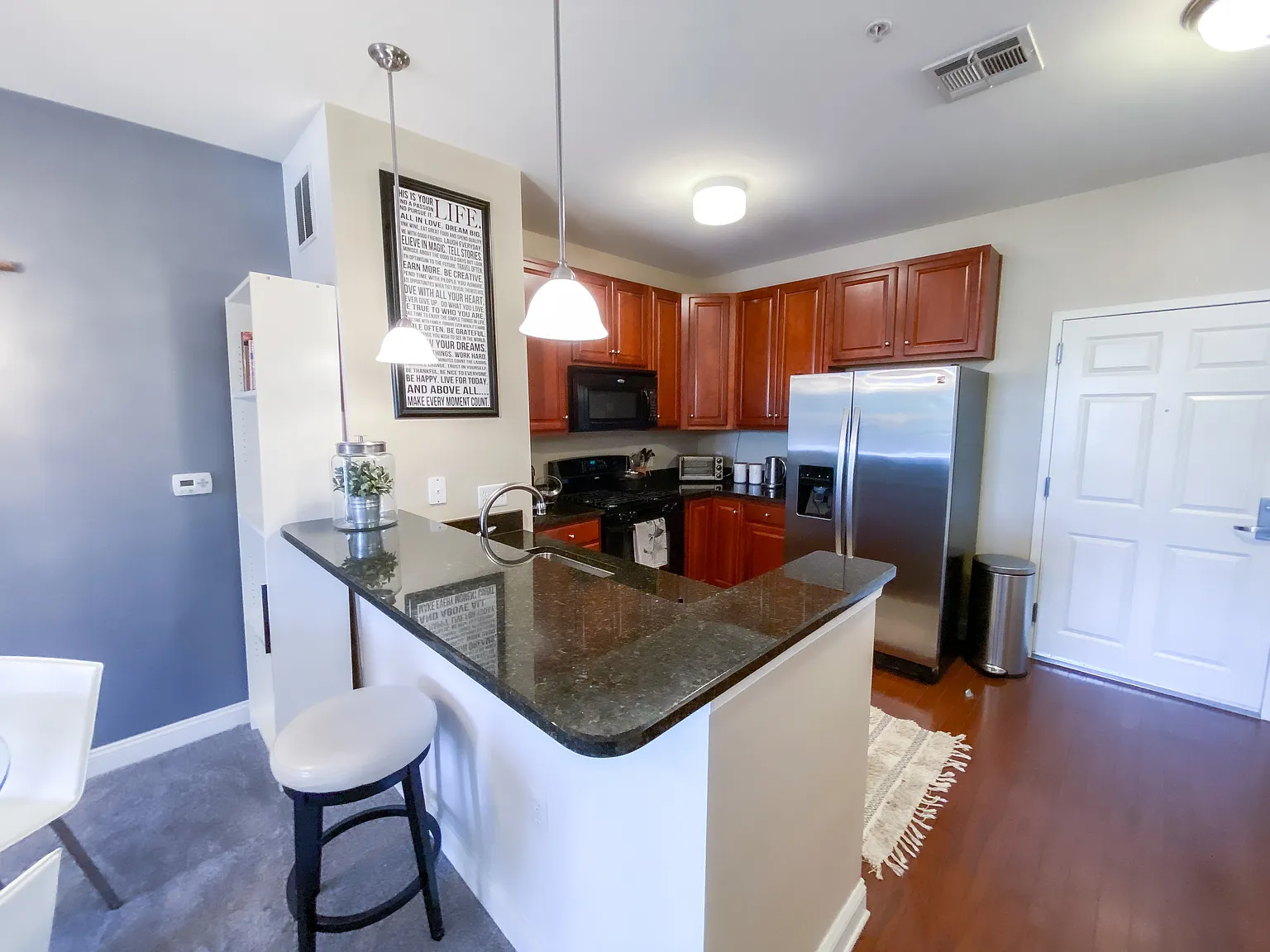 Kitchen with cherry cabinetry, granite countertops and hardwood flooring