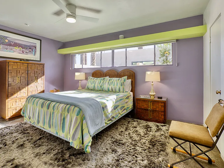 Second bedroom with queen bed and vintage brutalist furniture.