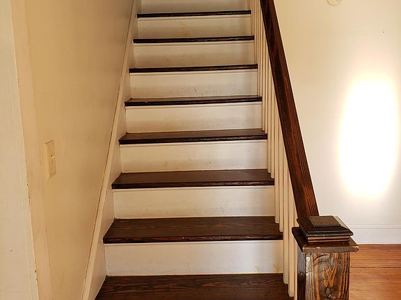 Stairs to second floor. Inside front door.