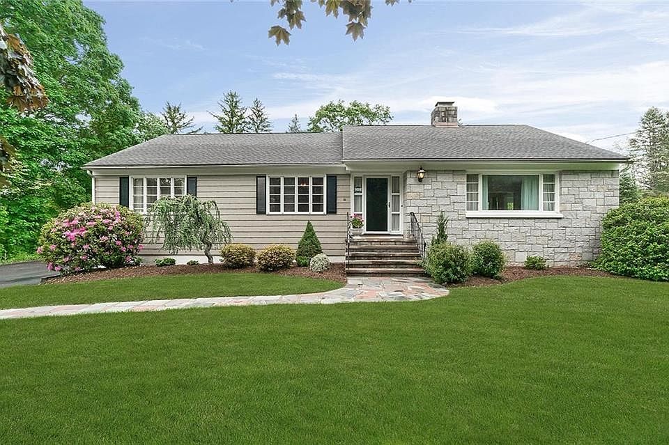 Exterior front picture of 12 Woodside Drive in Orange. Stone-facing exterior and professionally landscaped.