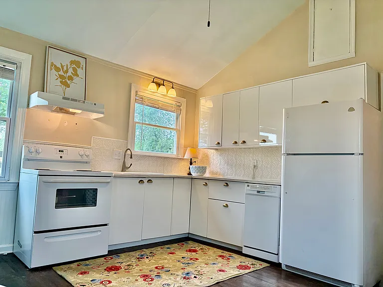 Cozy kitchen with full
Size fridge, stove and sink.