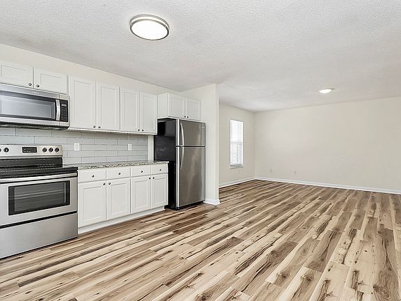 Kitchen and living room view from front door. Open floor plan.