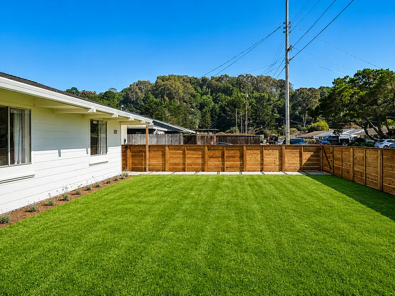 Inviting front yard with a large lawn and secure fencing for children and pets