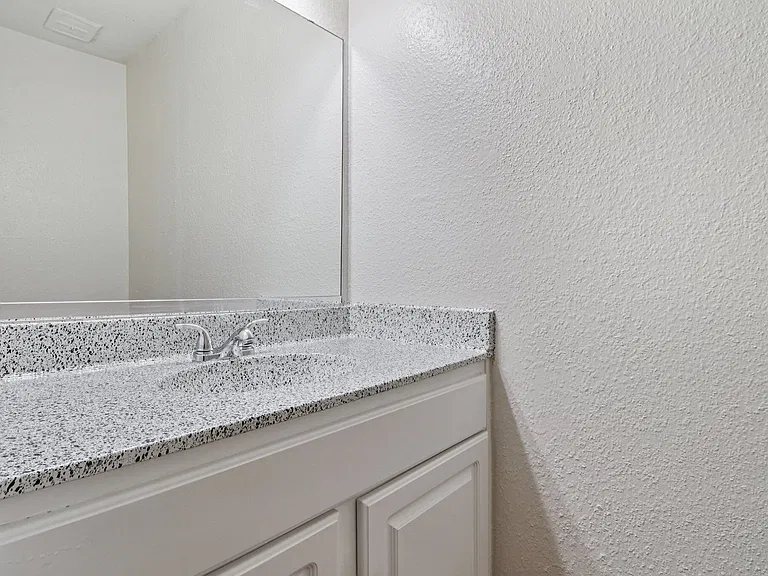 Modern bathroom vanity with sleek speckled countertop and stylish chrome faucet. Modern bathroom vanity with sleek speckled countertop and stylish chrome faucet.