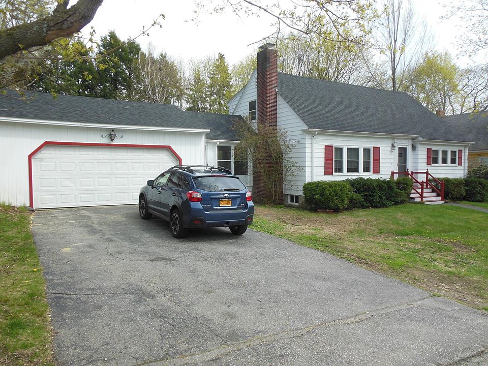 View from the street. Double garage connected by a screened in porch to house. Front window is living room, to the right the den/ bedroom