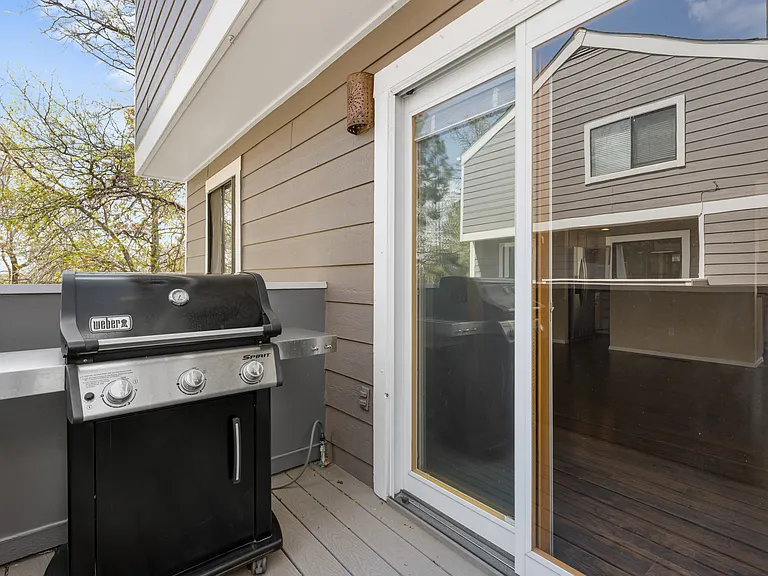 Private outdoor living space off the living room featuring an included Weber gas grill with attached gas line.