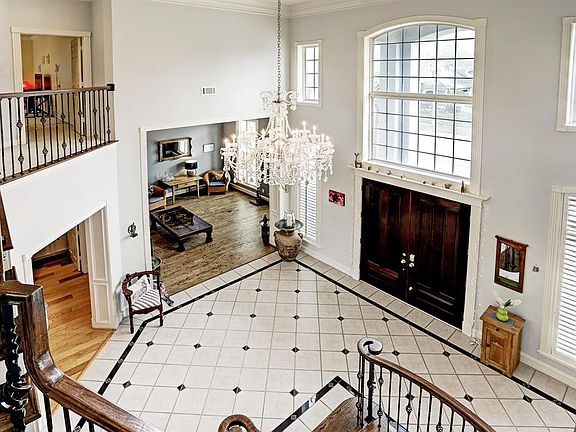 From the top of the stairwell looking down you will see the beautiful crystal chandelier in the entry, double wood doors, huge transom windows, custom wood casement molding and it is truly is a visual delight. The area is lets in tons of natural ligh