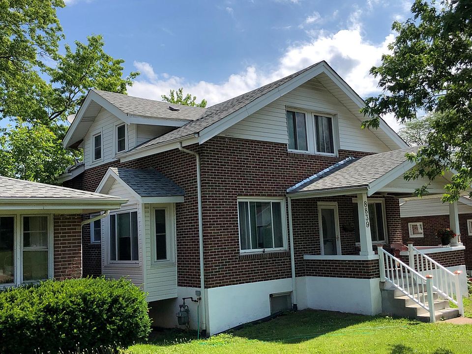 Brick bungalow with a bay window and a front porch on a quite street.