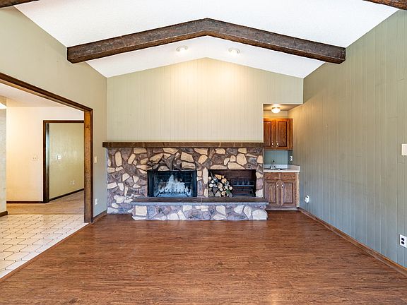 living room/den w/wood-burning fireplace + built in bar