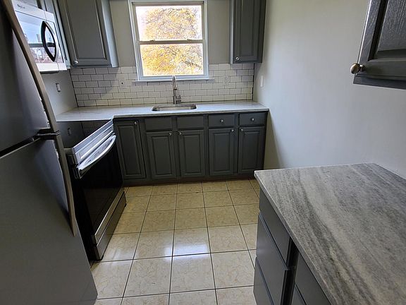 Updated kitchen with new counters, fixtures, and stainless steel appliances.