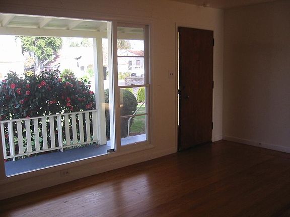 Large living room with large window and hardwood floors
