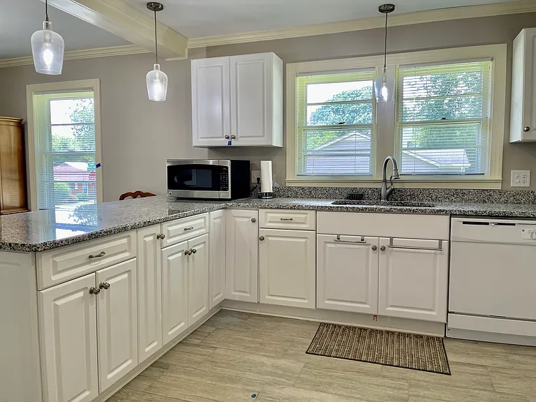 Spacious sunny kitchen adjoins eating area. LOTS of counter space and cabinetry! Dishwasher and double door refrigerator with ice/water in door are new. (Less than 1 yr old) Microwave not provided.